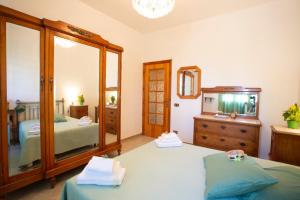 a bedroom with two beds and a mirror and a dresser at Casa Joseph in Cava dʼAliga