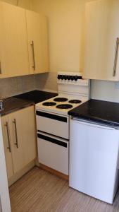 eine kleine Küche mit weißen Geräten und Schränken in der Unterkunft The Kathrene in Fleetwood