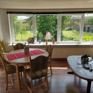 a dining room with a table and a large window at Villagehome North Jylland in Sindal