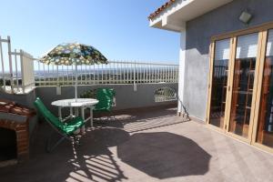 a patio with an umbrella and a table and chairs at Casa Joseph in Cava dʼAliga