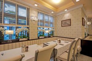 - une salle à manger avec des tables, des chaises et des fenêtres dans l'établissement Monaco Ville, à Międzyzdroje