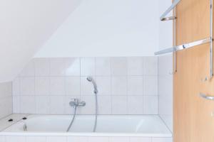 a bath tub with a shower in a bathroom at Hotel BUTZ in Scharbeutz