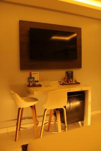 sala de estar con 2 sillas y mesa con TV en Nidore Motel en Boa Vista