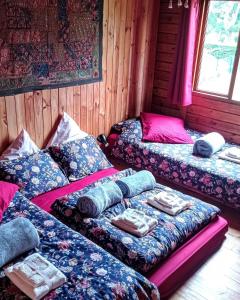 Zimmer mit 3 Betten und Kissen darauf in der Unterkunft Chalet TanZanTan in La Plaine des Palmistes