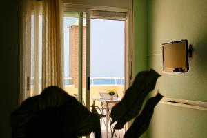 um quarto com paredes verdes e uma janela com vista em Primera línea de mar con terraza ático en Magic World - Marina Dor em Oropesa del Mar