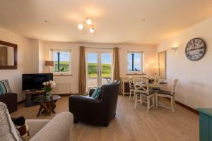 a living room with a couch and a table at White Lodge Apartments in Mawgan Porth