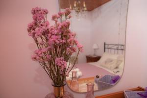 um vaso de flores cor-de-rosa em frente a um espelho em La Casa del Gelsomino em Acquaviva Picena
