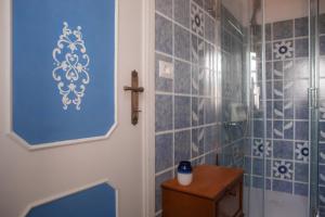 a bathroom with blue tiled walls and a shower at La Casa del Gelsomino in Acquaviva Picena