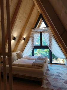 a bed in a room with a large window at Stone Chalets - TERRA in Jajce