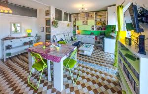 a kitchen with a table and green cabinets at Nice Apartment In Saint-tienne With Kitchen in Saint-Étienne