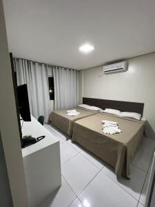 een hotelkamer met 2 bedden en een televisie bij RILL HOTEL BY UCHÔA in Teresina