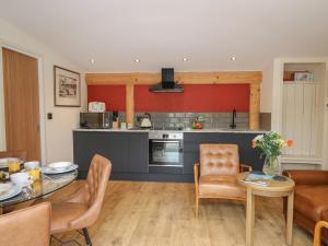 a kitchen and living room with a table and chairs at Fioled in Welshpool