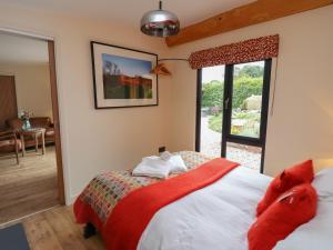 a bedroom with a bed with a red blanket at Fioled in Welshpool