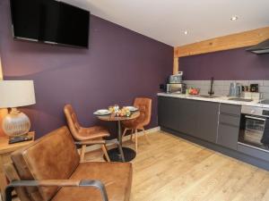 una cucina con pareti viola, tavolo e sedie di Daffodil a Welshpool