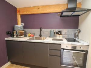 una piccola cucina con lavandino e piano cottura di Daffodil a Welshpool