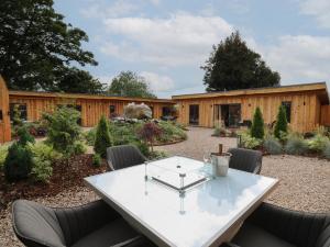 a patio with a table and chairs in a yard at Pansi in Welshpool