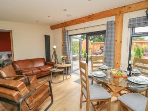 a living room with a glass table and chairs at Pansi in Welshpool +14 photos