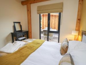1 dormitorio con cama y vistas a un patio en Rhosyn en Welshpool