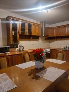 a kitchen with a table with a vase of flowers on it at Dom Tatrzański Widok in Bustryk +51 photos