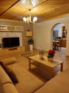 ein Wohnzimmer mit einem Sofa und einem Tisch in der Unterkunft Dom Tatrzański Widok in Bustryk