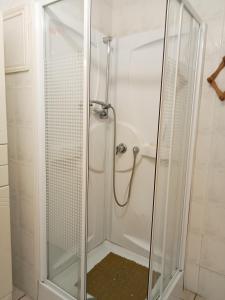 una doccia con porta in vetro in bagno di la cigogne a Céret