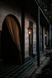 un bâtiment avec un portail et une lampe sur un sol en damier dans l'établissement Coqui Coqui Casa de los Santos Izamal - THE ONLY ONE SUITE COLLECTION, à Izamal