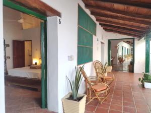 蒙波斯HOTEL NIETO MOMPOX, ubicado en el corazón del centro histórico, frente al rio magdalena en zona de malecón的一间卧室、一张床和椅子