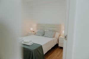 a bedroom with a white bed and a table at Vimar Algarrobo Costa in Algarrobo-Costa