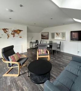 een woonkamer met een bank, stoelen en een tafel bij Very Central, Charlotte Square, near the Castle in Edinburgh
