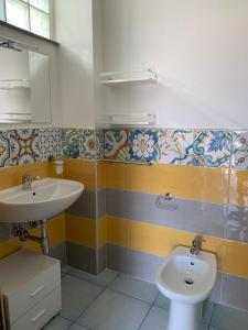 a bathroom with a sink and a toilet at Tuttiacasaditeresa Rooms in Procida
