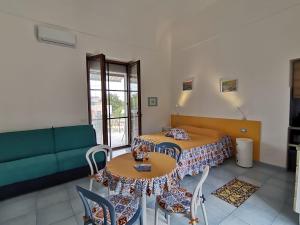 a living room with two tables and a couch at Tuttiacasaditeresa Rooms in Procida