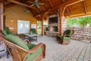 a screened in porch with chairs and a fireplace at Lakefront Langley Retreat with Decks and Great Views! in Spavinaw