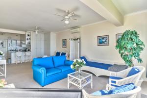 a living room with a blue couch and chairs at 3 Sandringham Sea Facing ground-floor Studio in Cape Town