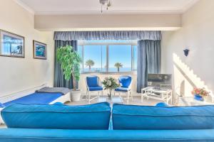 a bedroom with a blue couch and blue chairs at 3 Sandringham Sea Facing ground-floor Studio in Cape Town