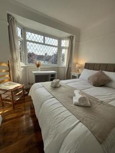 a bedroom with two beds and a chair and a window at Beautiful house/Parking in Plumstead