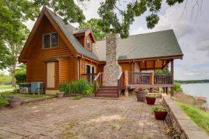 a log home with a patio and a porch at Lakefront Langley Retreat with Decks and Great Views! in Spavinaw