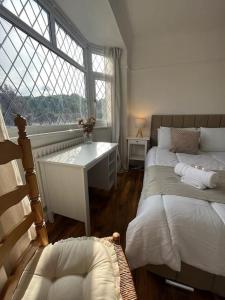 a bedroom with two beds and a desk and a window at Beautiful house/Parking in Plumstead +16 photos