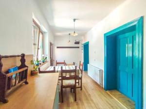 comedor con mesa y puerta azul en Blue Home, en Avrig