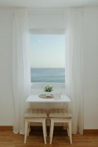 a table and two benches in a room with a window at Vimar Algarrobo Costa in Algarrobo-Costa