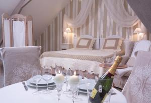 a room with a table with a bottle of champagne and glasses at Côte d'Opale - La Ferme des Saules in Millam