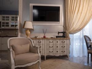 sala de estar con silla y tocador con TV en Romantico Mood, en Porto SantʼElpidio