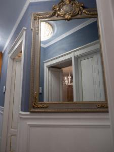 un espejo con un marco dorado en una pared azul en Romantico Mood, en Porto SantʼElpidio