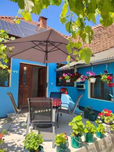 un patio con mesa, sillas y sombrilla en Blue Home, en Avrig