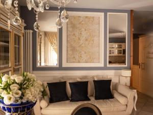 una sala de estar con sofá y un jarrón de flores en Romantico Mood, en Porto SantʼElpidio
