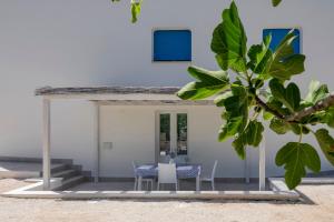 マルティナ・フランカにあるCasa Vacanze Villa Grecaのビーチにテーブルと椅子がある家