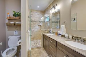 a bathroom with a toilet and two sinks and a shower at Dock and Yard Games Lakefront Michigan Getaway! in Free Soil +36 photos