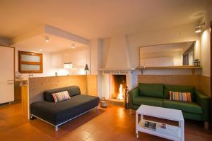 un soggiorno con divano verde e camino di Salitres Increíbles vistas a 50m de la playa a Tamariu