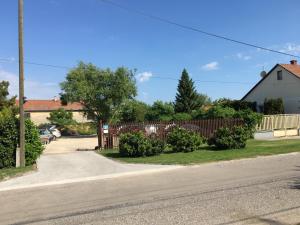 a street with a wooden fence and a driveway at Ida panzió in Lajosmizse