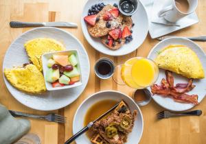 a wooden table topped with plates of breakfast foods at The Westin Resort & Spa, Whistler in Whistler