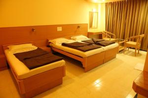 Postel nebo postele na pokoji v ubytování Hotel Ravikiran Alibaug
